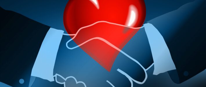Zwei Hände mit Handschlag und ein rotes Herz