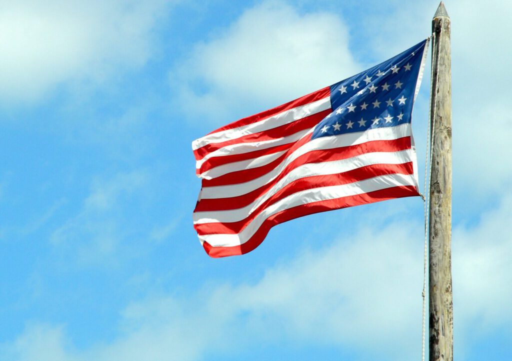 Eine US-Flagge im Wind an einem Holzmast