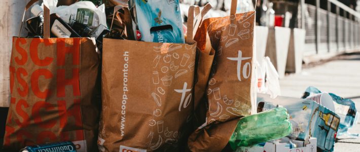 Kantonale Millionen für die Abfallentsorgung Abfalltüten um Coop und Migros auf einer Schweizer Strasse