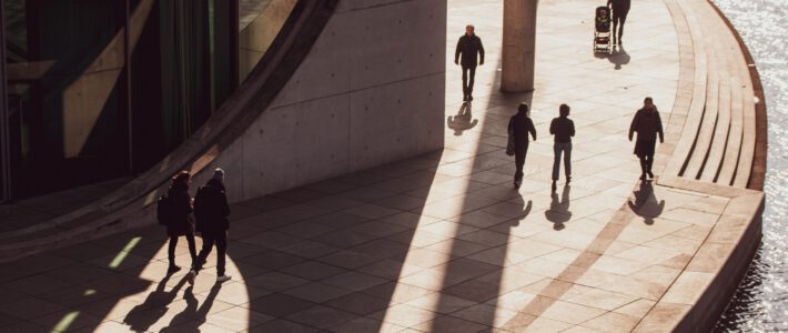 Menschen auf einer Strasse mit Sonne und Schatten