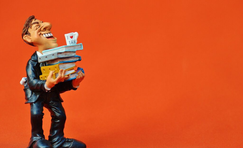 Ein Steuerbeamter mit vielen Ordnern auf den Armen und einer Kaffeetasse