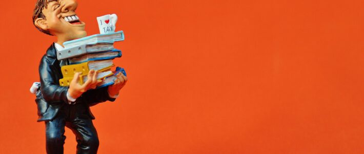 Ein Steuerbeamter mit vielen Ordnern auf den Armen und einer Kaffeetasse