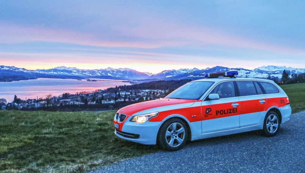 Ein Polizeiauto vor einem See und den Bergen