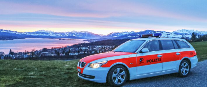 Behörden schnappen sich Insidertrader Ein Polizeiauto vor einem See und den Bergen