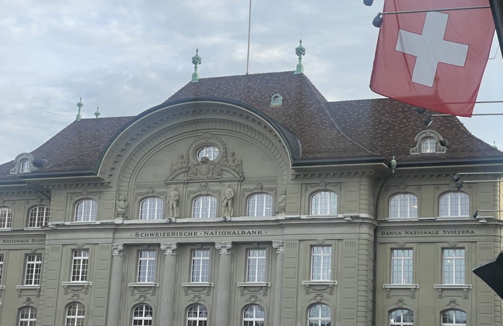 SNB-Sitz in Bern mit Schweizerflagge am Parlament