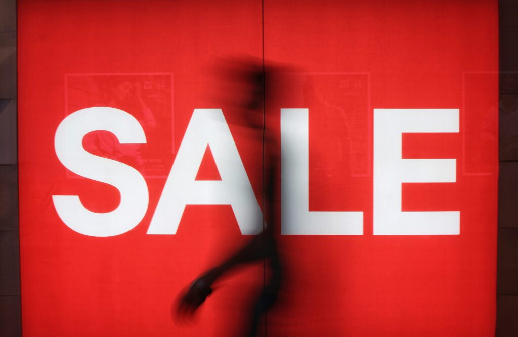 Ein Sale-Schild in einem Schaufenster mit einer Person davor