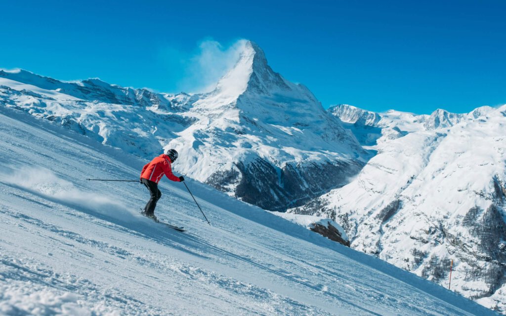 Skifahrer auf einer Piste und im Hintergrund das Matterhorn
