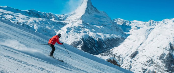 Walliser und Bündner brauchen mehr Kopfschutz Skifahrer auf einer Piste und im Hintergrund das Matterhorn
