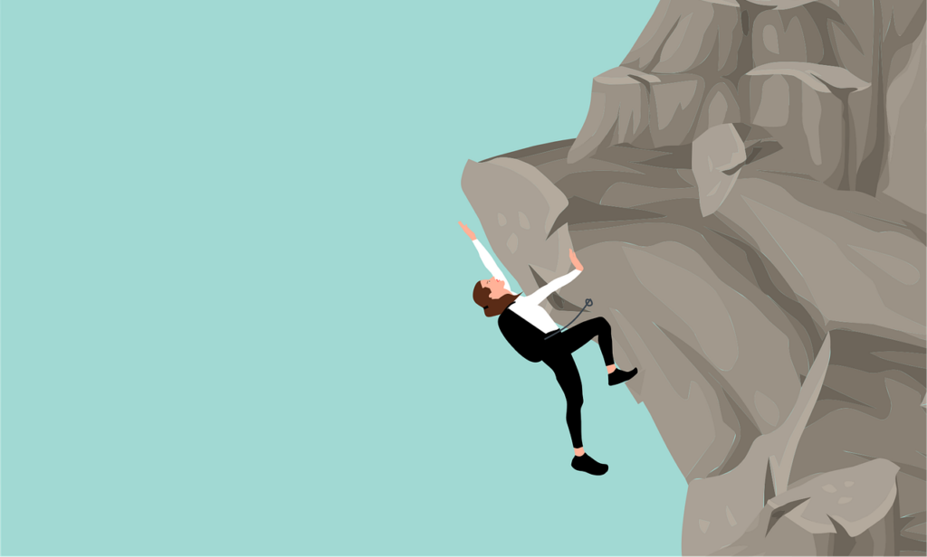 Eine Person hängt an einem Felsen und klettert nach oben