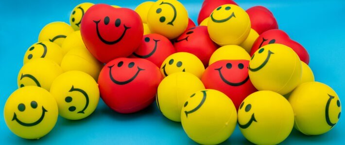 Rote und gelbe Smile-Bälle auf blauem Grund