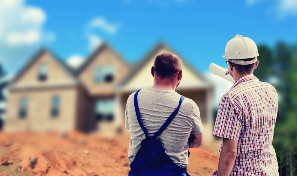 Zwei Bauarbeiter vor einer Baustelle