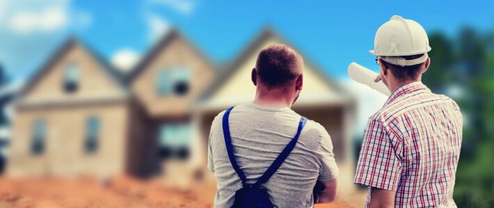 Zwei Bauarbeiter vor einer Baustelle