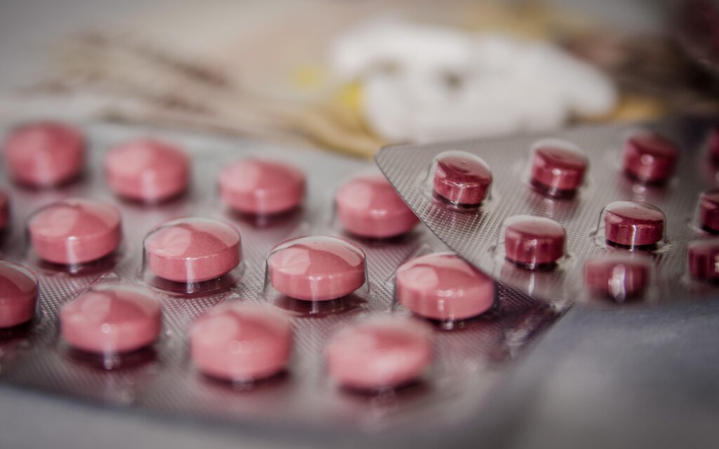 Tabletten unterschiedlicher Farbe in Verpackungen