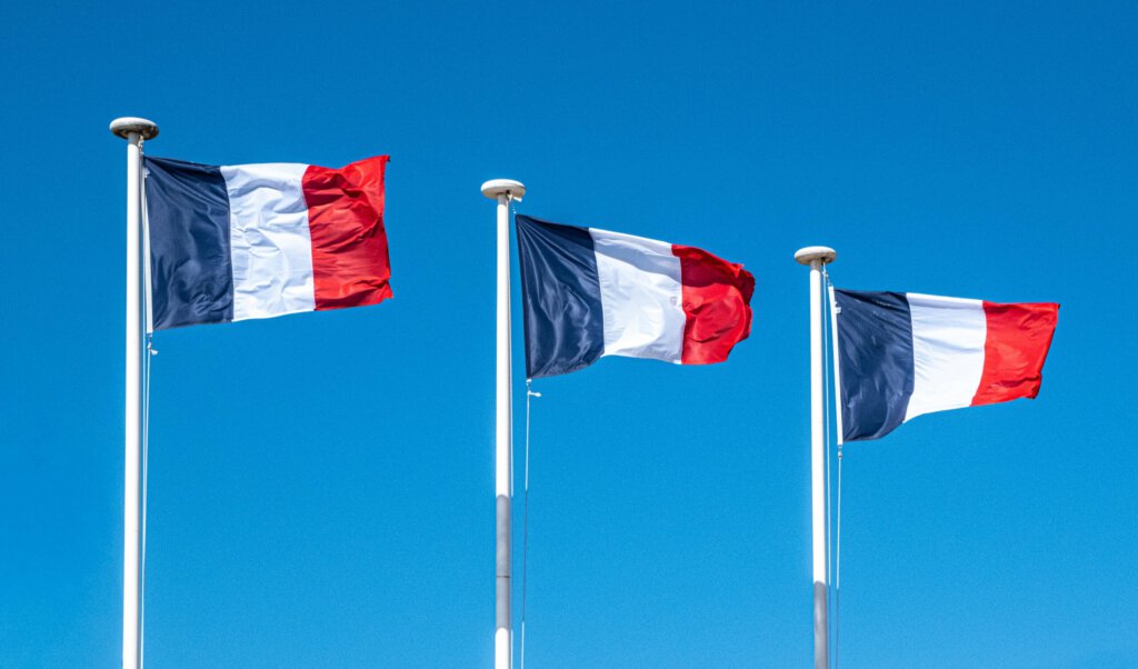 Drei französische Flaggen an Fahnenmasten
