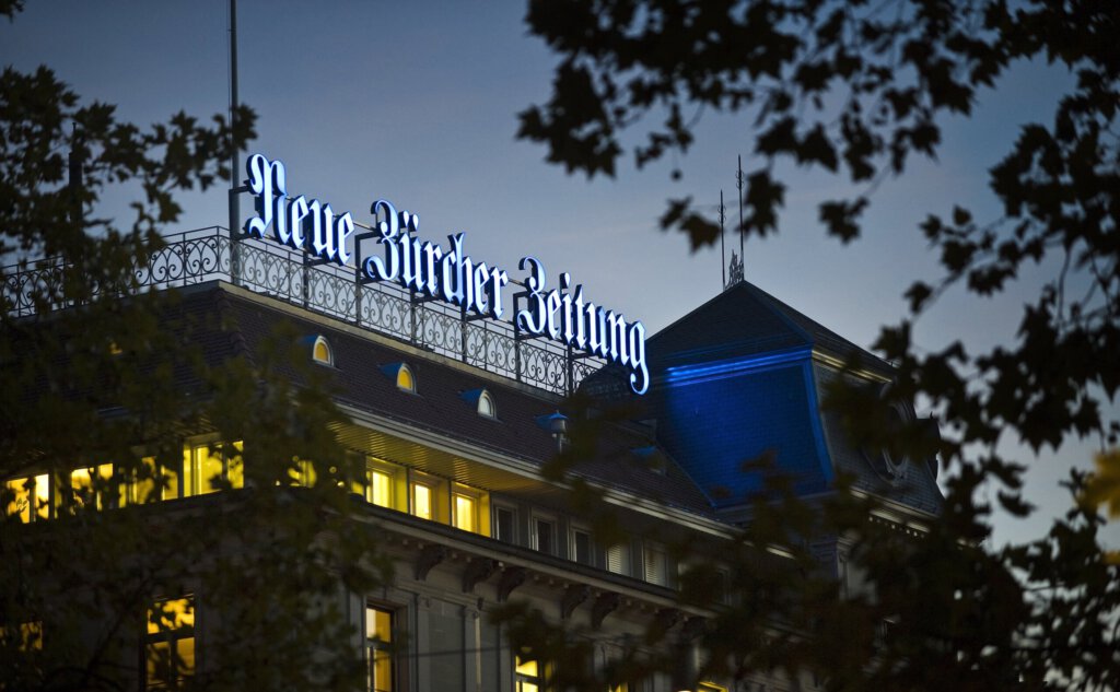 Das Logo der NZZ auf dem Verlagsgebäude in Zürich bei Nacht