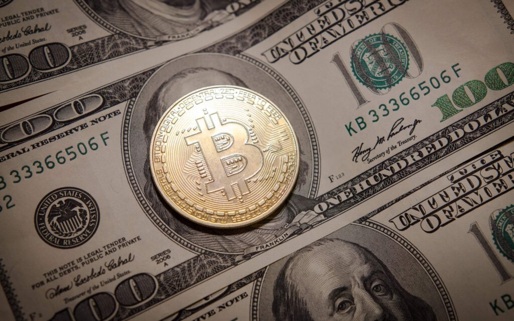 Ein Bitcoin auf einem Dollar-Schein