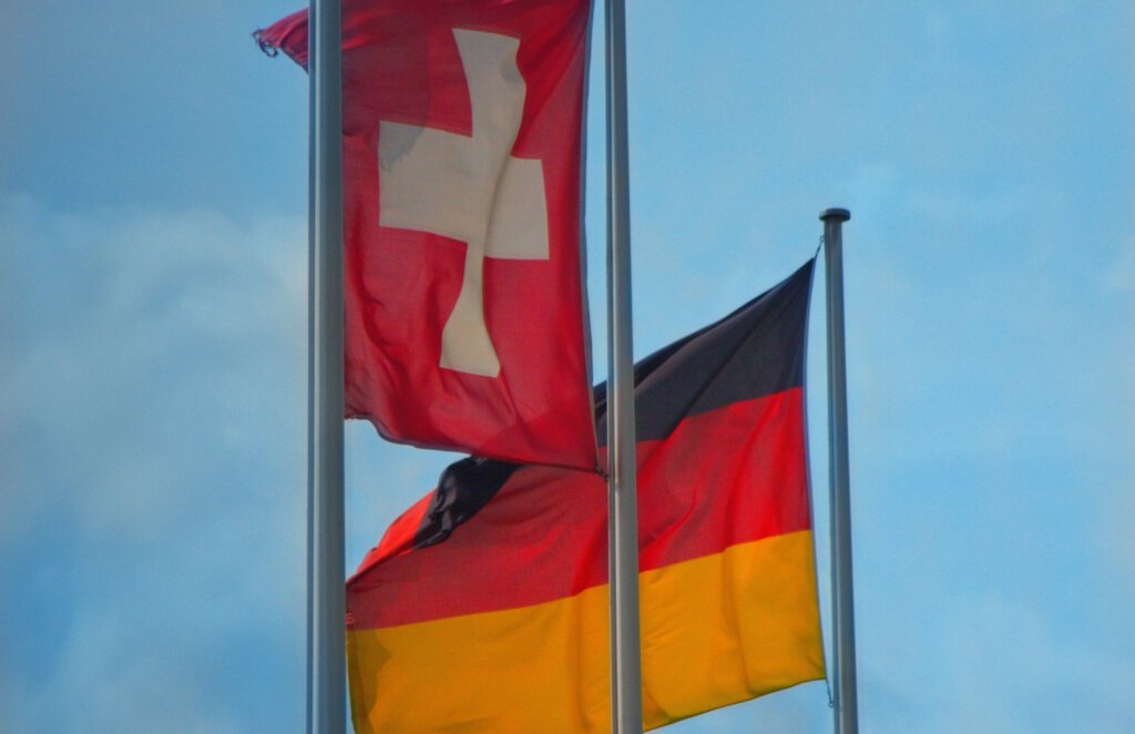 Eine Schweizer und eine deutsche Flagge im Wind