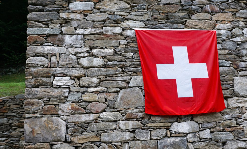 Eine Schweizerflagge an einer Steinmauer