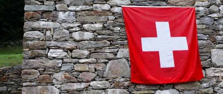 Mehr Schweizer kehren ihrer Heimat den Rücken Eine Schweizerflagge an einer Steinmauer