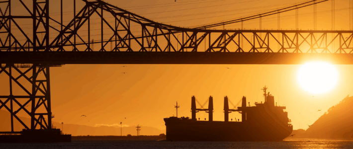 Erdölpreis geht durch die Decke Ein Erdöltanker unter einer Brücke beim Sonnenuntergang