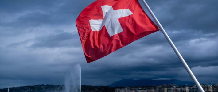 Eine Schweizer Flagge im Wind beim Genfersee