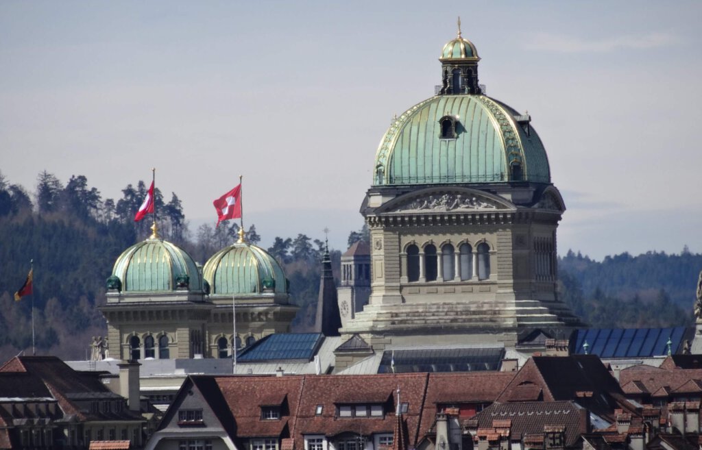 Bundeshaus in Bern mit Schweizer Flaggen