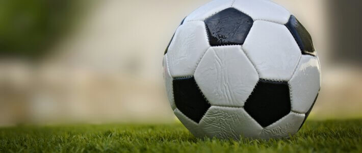 Ein grosser Fussball auf einem Spielfeld