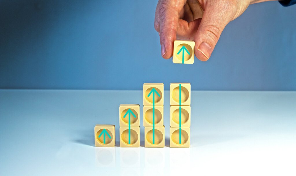 Pfeile nach oben in Würfeln mit einer Hand