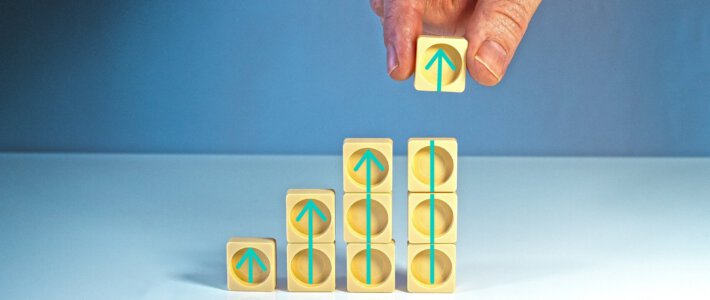 Pfeile nach oben in Würfeln mit einer Hand