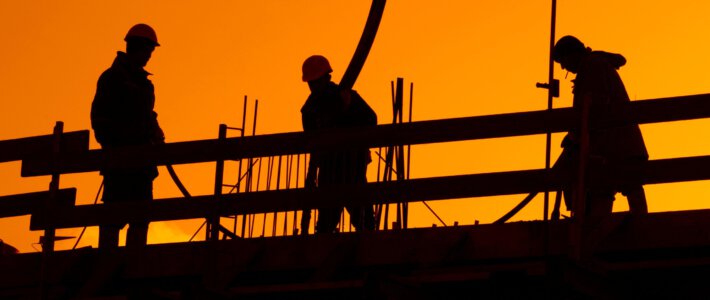 Arbeiter auf einer Baustelle vor Sonnenuntergang