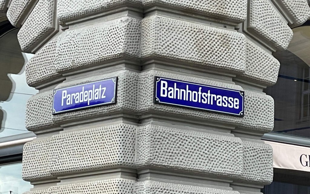 Schilder Paradeplatz und Bahnhofstrasse an einem Haus in Zürich