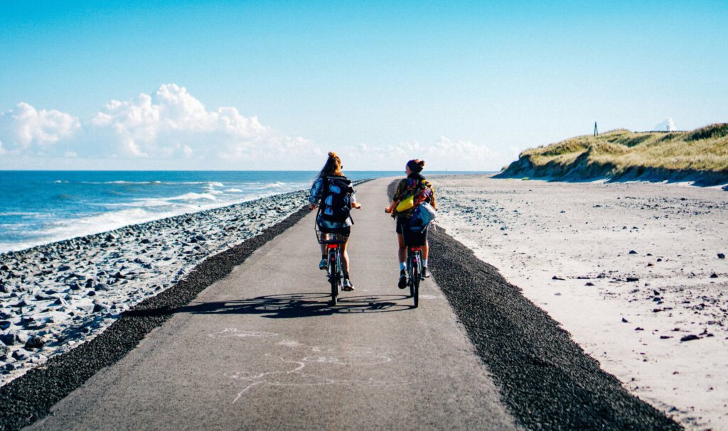 Zwei Frauen auf Fahrrädern am Meer