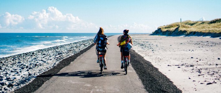 Zwei Frauen auf Fahrrädern am Meer