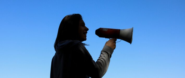 Verhärtung der Fronten am Schweizer Arbeitsmarkt Eine Frau mit einem Megaphone