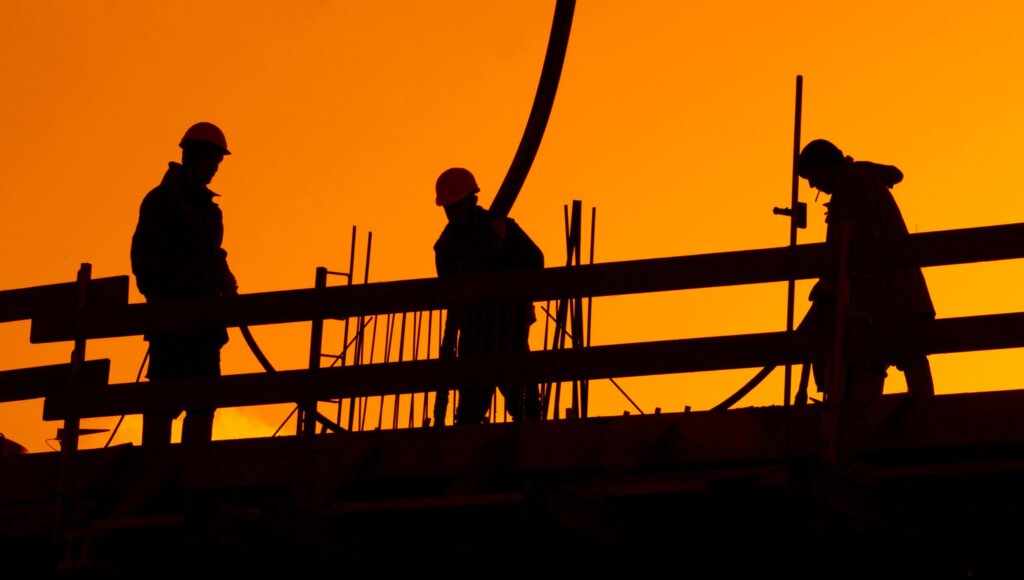 Schematische Sicht auf Arbeiter an einer Baustelle