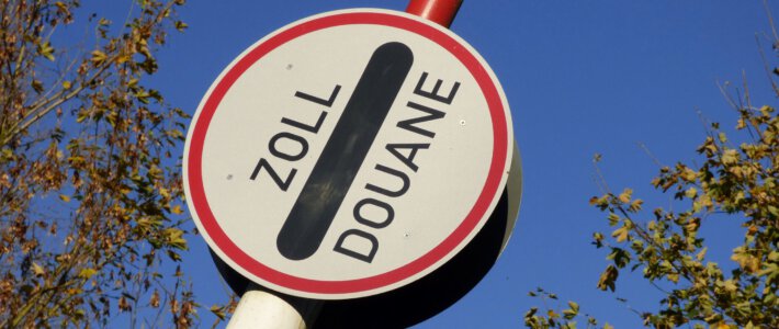 Schweiz verschlechtert Einkaufstourismus erfolgreich Eine Zollschranke vor blauem Himmel und Bäumen