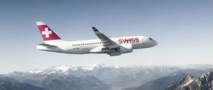 Swiss verschmutzt Umwelt für das Marketing Ein Airbus A220 der Swiss in der Luft mit Alpen im Hintergrund