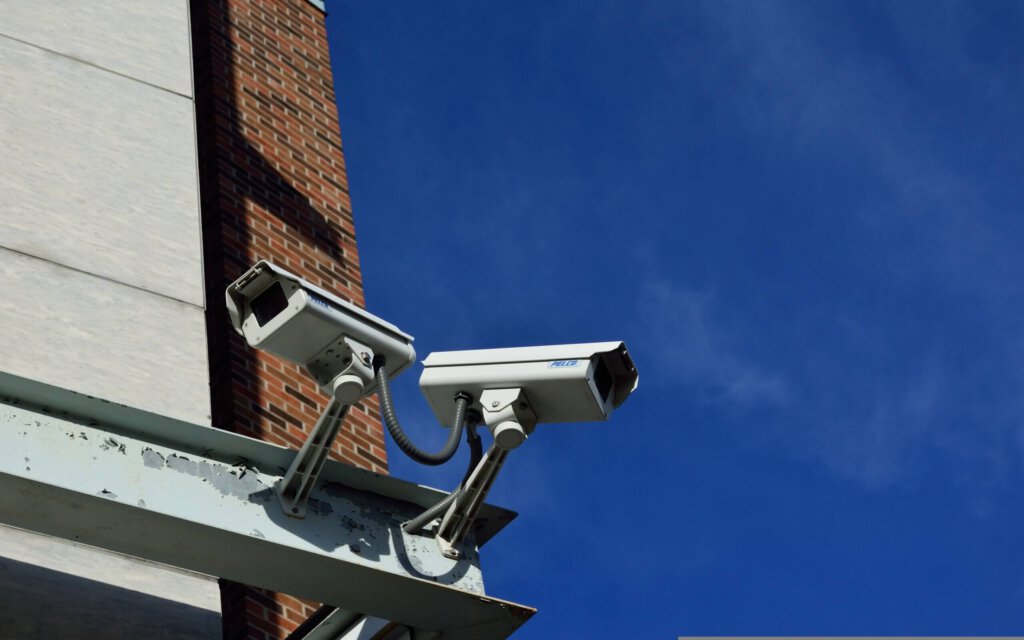 CCTV-Kameras an einem Gebäude vor blauem Himmel
