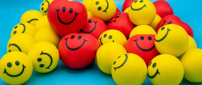 Schweizer Konsumenten optimistischer Bunte Smileys vor blauem Hintergrund