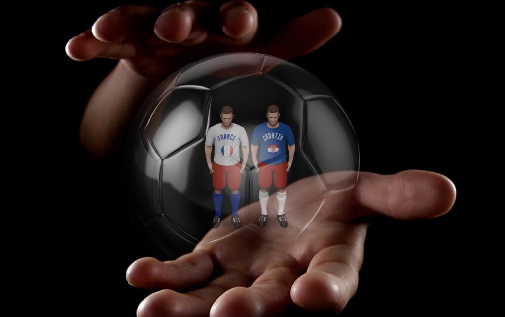 Zwei Hände um einen gläsernen Fussball mit zwei Spielerfiguren drin