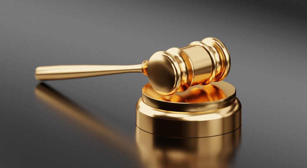 Ein goldener Auktionshammer mit grauem Hintergrund