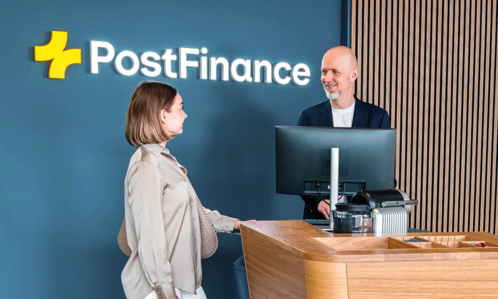 Eine Filiale von Postfinance mit Logo an der Wand