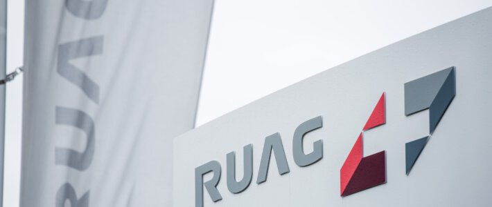Ruag stürzt Schweiz in Cyber-Chaos Logo und Fahne des staatlichen Rüstungskonzerns Ruag