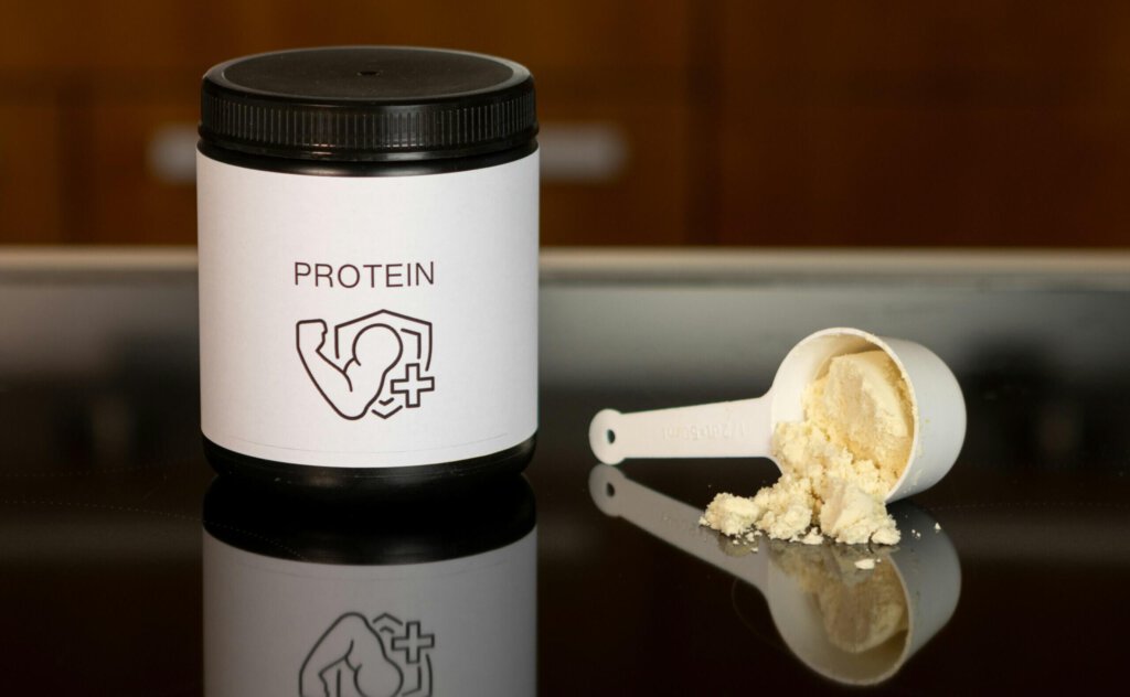 Protein-Pulver in einer Dose und auf einen Löffel