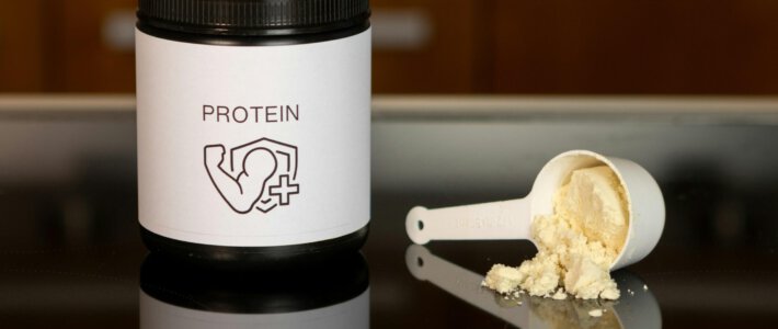 Protein-Pulver in einer Dose und auf einen Löffel