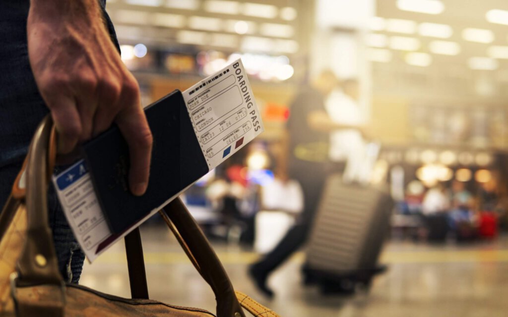Eine Person mit einem Flugticket in einem Reisepass an einem Flughafen