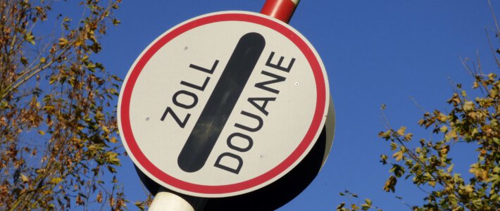 Blühender Schmuggel von Lebensmitteln Ein Schild «Zoll/Douane» an einer Schranke